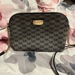 Super cute Michael Kors cross body purse. Gold accents, black & grey color.